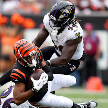 Sep 17, 2023; Cincinnati, Ohio, USA; Cincinnati Bengals wide receiver Tyler Boyd (83) is tackled after a catch by Baltimore Ravens safety Geno Stone (26) and Baltimore Ravens linebacker David Ojabo (90) in the third quarter at Paycor Stadium. Mandatory Credit: Albert Cesare-Imagn Images