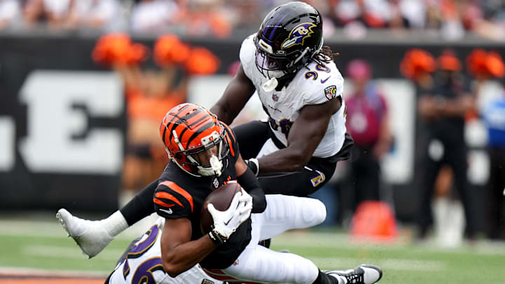 Sep 17, 2023; Cincinnati, Ohio, USA; Cincinnati Bengals wide receiver Tyler Boyd (83) is tackled after a catch by Baltimore Ravens safety Geno Stone (26) and Baltimore Ravens linebacker David Ojabo (90) in the third quarter at Paycor Stadium. Mandatory Credit: Albert Cesare-Imagn Images