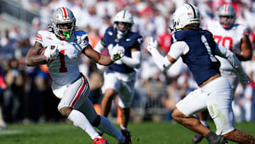 Ohio State Buckeyes running back Quinshon Judkins (1) runs around Penn State Nittany Lions safety Jaylen Reed (1) during a Big Ten football game at Beaver Stadium.