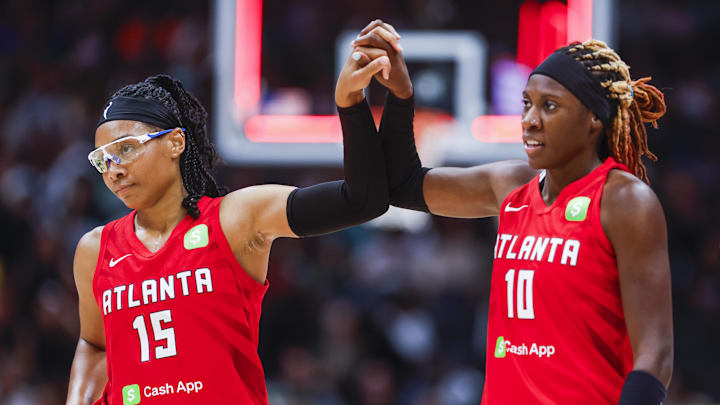 Aug 13, 2025; Seattle, Washington, USA; Atlanta Dream guard Allisha Gray (15) celebrates with guard Rhyne Howard (10) following a victory against the Seattle Storm at Climate Pledge Arena. Mandatory Credit: Joe Nicholson-Imagn Images