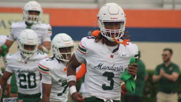 Mandarin cornerbacks Brody Jennings (3) and Tamajh Mitchell (7) lead teammates through pregame warm-ups before a high school spring football game at Bolles on May 22, 2025. [Clayton Freeman/Florida Times-Union]