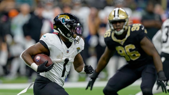 Oct 19, 2023; New Orleans, Louisiana, USA; Jacksonville Jaguars running back Travis Etienne Jr. (1) runs against New Orleans Saints defensive end Carl Granderson (96) during the third quarter at the Caesars Superdome. Mandatory Credit: Matthew Hinton-USA TODAY Sports
