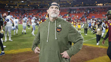 Washington Commanders head coach Dan Quinn stands on the field following a loss to the Detroit Lions at Northwest Stadium.