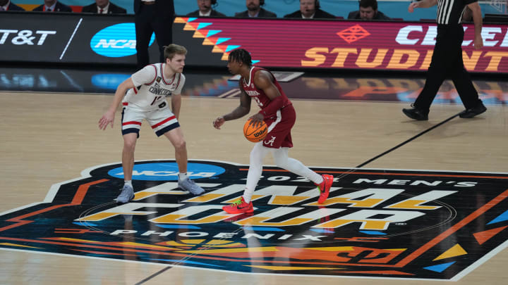 Alabama guard Latrell Wrightsell Jr. dribbles the ball up the court against Connecticut guard Cam Spencer 