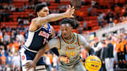 Jan 21, 2025; Stillwater, Oklahoma, USA; Oklahoma State Cowboys guard Jamyron Keller (14) drives around Arizona Wildcats guard Caleb Love (1) during the first half at Gallagher-Iba Arena. Mandatory Credit: William Purnell-Imagn Images