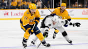 Nov 4, 2024; Nashville, Tennessee, USA;  Nashville Predators right wing Luke Evangelista (77) and Los Angeles Kings right wing Adrian Kempe (9) fight for the puck during the third period at Bridgestone Arena. Mandatory Credit: Steve Roberts-Imagn Images