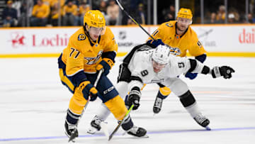Nov 4, 2024; Nashville, Tennessee, USA;  Nashville Predators right wing Luke Evangelista (77) and Los Angeles Kings right wing Adrian Kempe (9) fight for the puck during the third period at Bridgestone Arena. Mandatory Credit: Steve Roberts-Imagn Images