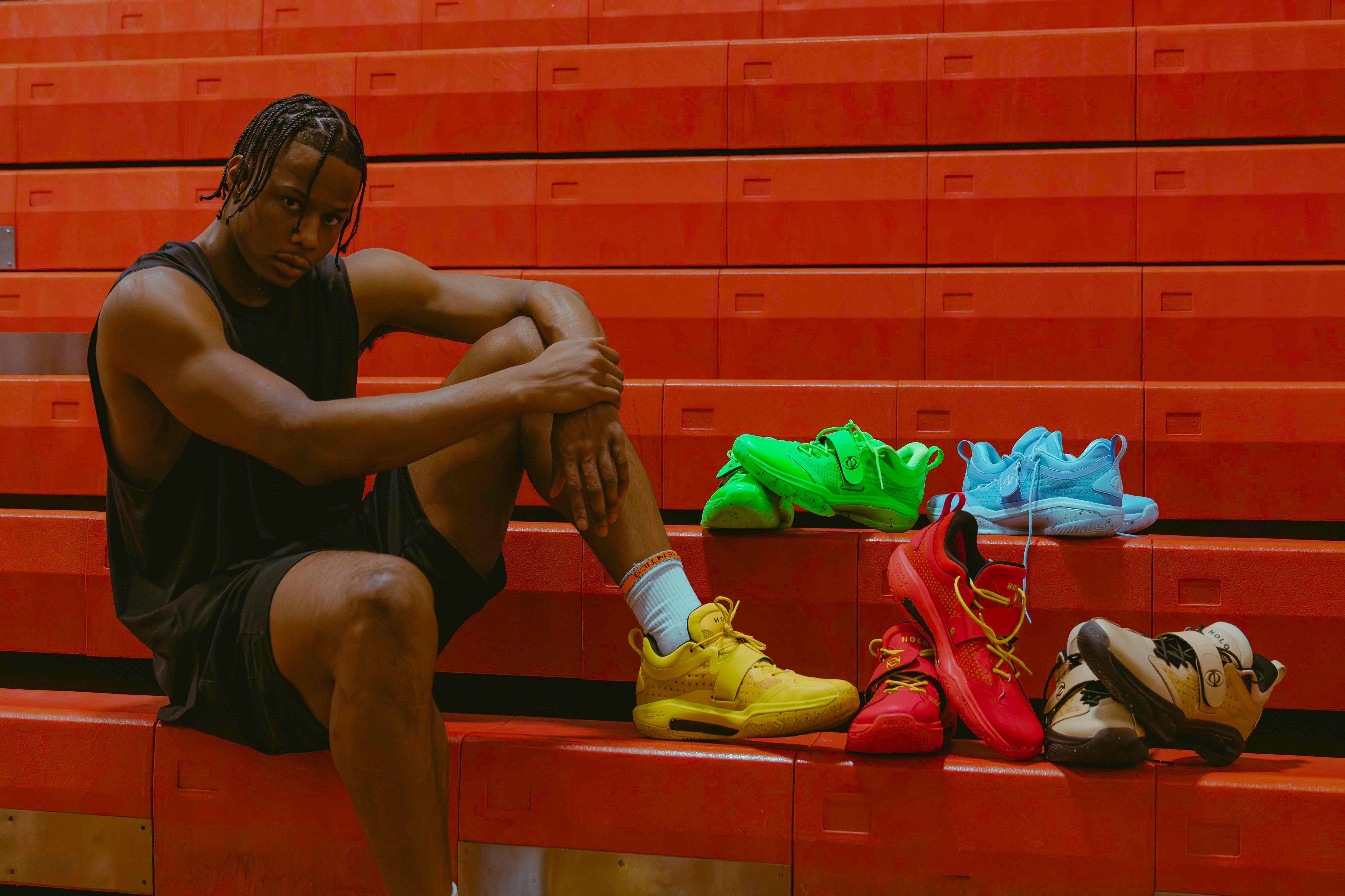 Isaac Okoro sits on bleachers next to his multicolor sneakers.