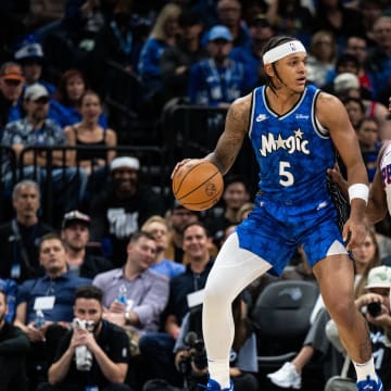Jan 19, 2024; Orlando, Florida, USA; Orlando Magic forward Paolo Banchero (5) dribbles the ball against Philadelphia 76ers point guard Tyrese Maxey (0) in the first quarter at KIA Center. Mandatory Credit: Jeremy Reper-USA TODAY Sports