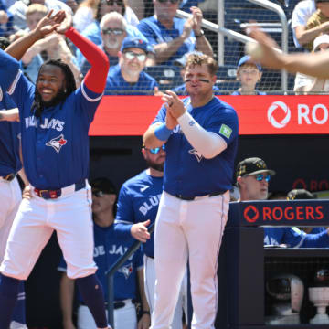 May 19, 2024; Toronto, Ontario, CAN;   Toronto Blue Jays right fielder George Springer (4) is greeted at the dugout by first baseman Vladimir Guerrero Jr. (27) an designated hitter Daniel Vogelbach (20) after scoring against the Tampa Bays Rays in the fourth inning at Rogers Centre.