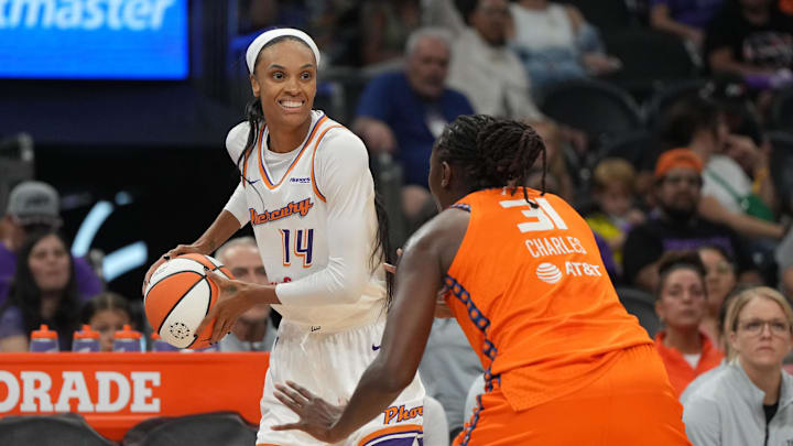 Aug 5, 2025; Phoenix, Arizona, USA; Phoenix Mercury forward DeWanna Bonner (14) shields the ball from Connecticut Sun center Tina Charles (31) in the first half at Footprint Center. Mandatory Credit: Rick Scuteri-Imagn Images