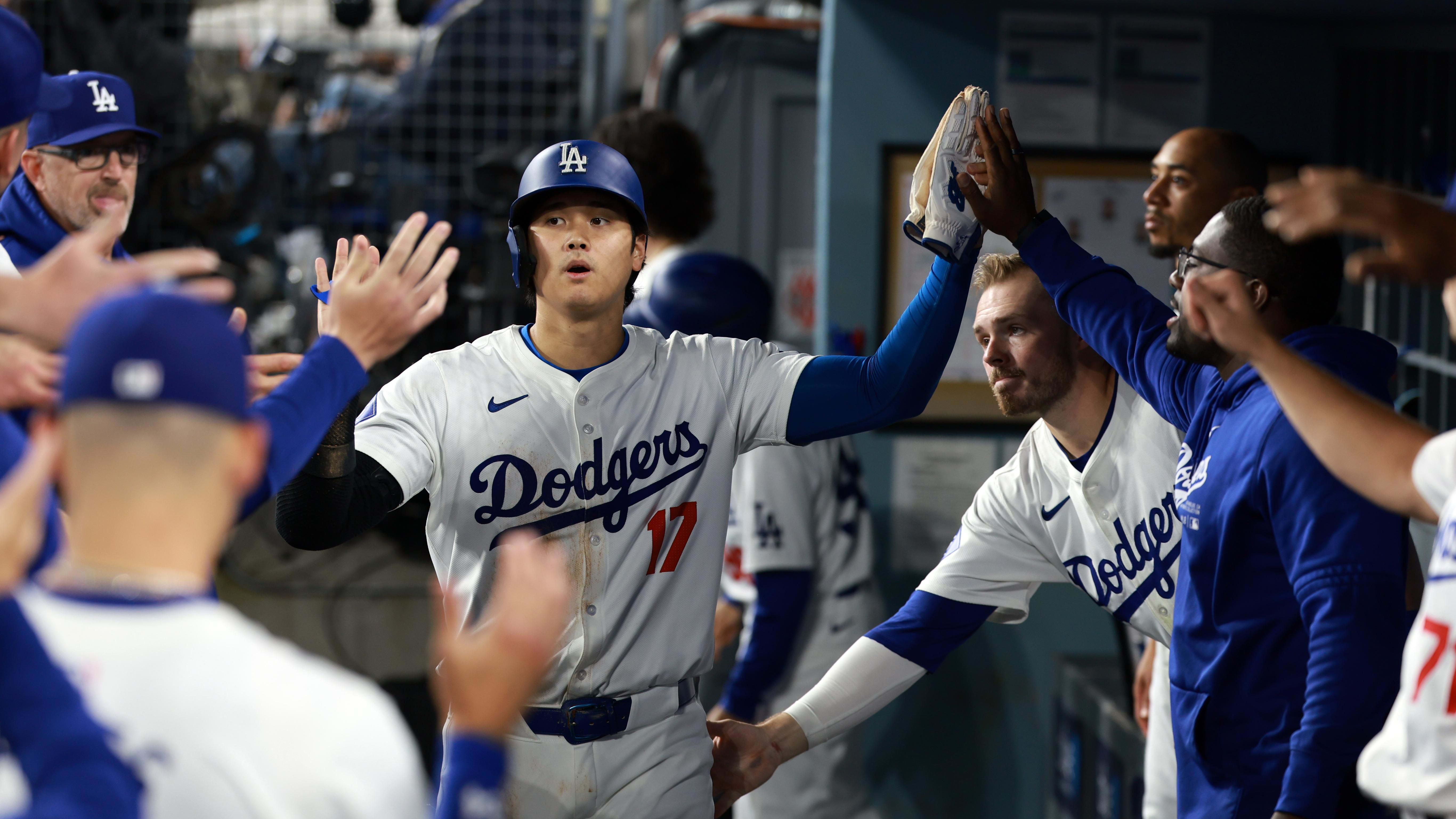 Los Angeles Dodgers designated hitter Shohei Ohtani celebrates with his teammates after hitting the game-tying single in the 9th inning to send their matchup with the Atlanta Braves to extra innings. 
