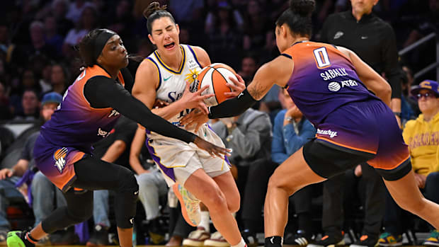 A photo of Kahleah Copper and Satou Sabally defending Kelsey Plu