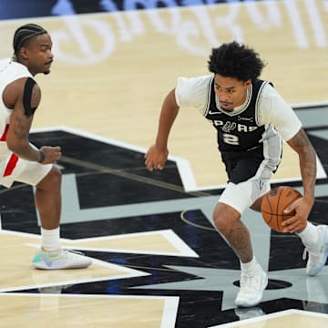 Oct 27, 2025; San Antonio, Texas, USA;  San Antonio Spurs guard Dylan Harper (2) dribbles past Toronto Raptors guard Jamal Shead (23) in the second half at Frost Bank Center.