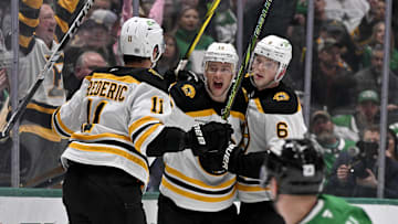 Nov 14, 2024; Dallas, Texas, USA; Boston Bruins center Trent Frederic (11) and center Charlie Coyle (13) and defenseman Mason Lohrei (6) celebrates a goal scored by Coyle against the Dallas Stars during the first period at the American Airlines Center. Mandatory Credit: Jerome Miron-Imagn Images
