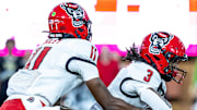 Sep 11, 2025; Winston-Salem, North Carolina, USA;  North Carolina State Wolfpack quarterback CJ Bailey (11) hands off to Hollywood Smothers (3) in the first half against the Wake Forest Demon Deacons at Allegacy Federal Credit Union Stadium. Mandatory Credit: Luke Jamroz-Imagn Images