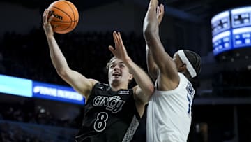 Dec 14, 2024; Cincinnati, Ohio, USA; Cincinnati Bearcats guard Connor Hickman (8) drives to the basket against Xavier Musketeers guard Ryan Conwell (7) in the second half at Fifth Third Arena. Mandatory Credit: Aaron Doster-Imagn Images