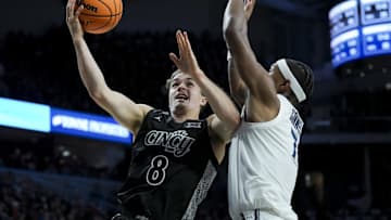 Dec 14, 2024; Cincinnati, Ohio, USA; Cincinnati Bearcats guard Connor Hickman (8) drives to the basket against Xavier Musketeers guard Ryan Conwell (7) in the second half at Fifth Third Arena. Mandatory Credit: Aaron Doster-Imagn Images