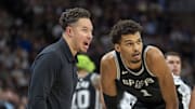 Dec 29, 2024; Minneapolis, Minnesota, USA; San Antonio Spurs interim head coach Mitch Johnson talks with center Victor Wembanyama (1) and guard Tre Jones (33) during a free throw against the Minnesota Timberwolves in the second half at Target Center.