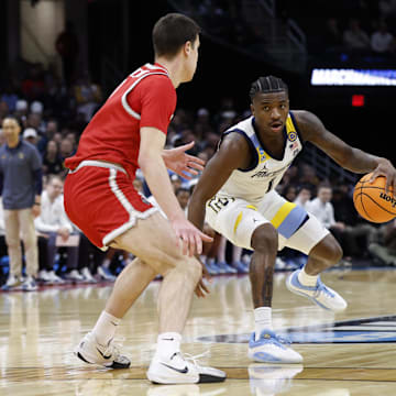Mar 21, 2025; Cleveland, OH, USA; Marquette Golden Eagles guard Kam Jones (1) plays the ball defended by New Mexico Lobos forward Filip Borovicanin (8) in the first half  during the  NCAA Tournament First Round at Rocket Arena. Mandatory Credit: Rick Osentoski-Imagn Images