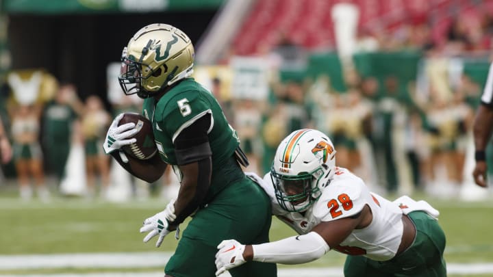 Sep 9, 2023; Tampa, Florida, USA; South Florida Bulls running back Nay'Quan Wright (5) outruns a tackle from Florida A&M Rattlers linebacker Johnny Chaney Jr. (28) during the first quarter at Raymond James Stadium. Mandatory Credit: Morgan Tencza-USA TODAY Sports