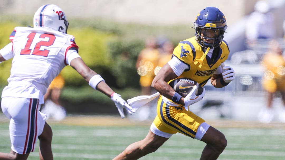 Aug 30, 2025; Morgantown, West Virginia, USA; West Virginia Mountaineers wide receiver Cam Vaughn (4) catches a ball and runs for extra yards during the first quarter against the Robert Morris Colonials at Milan Puskar Stadium. Mandatory Credit: Ben Queen-Imagn Images