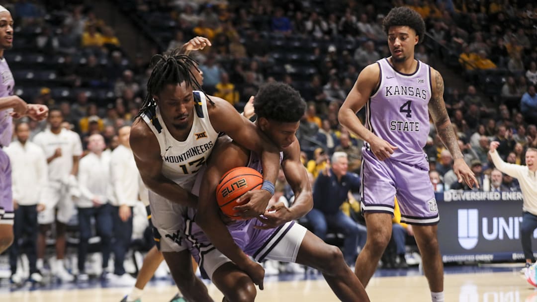 Jan 27, 2026; Morgantown, West Virginia, USA; West Virginia Mountaineers guard Chance Moore (13) Kansas State Wildcats forward Taj Manning (15) fight for a ball during the second half at Hope Coliseum. Mandatory Credit: Ben Queen-Imagn Imagesa