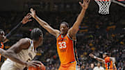 Jan 4, 2025; Morgantown, West Virginia, USA; Oklahoma State Cowboys forward Abou Ousmane (33) defends West Virginia Mountaineers guard Toby Okani (5) during the first half at WVU Coliseum. Mandatory Credit: Ben Queen-Imagn Images