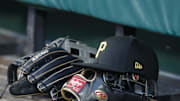 Aug 8, 2023; Pittsburgh, Pennsylvania, USA;  Pittsburgh Pirates hat and gloves in the dugout against the Atlanta Braves during the fourth inning at PNC Park. Mandatory Credit: Charles LeClaire-Imagn Images