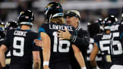 Jacksonville Jaguars quarterback Trevor Lawrence (16) is patted on the back by head coach Doug