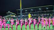 The teams perform a kick line during the Savannah Bananas first home game of the season on Friday, Feb. 21, 2025 at Historic Grayson Stadium.