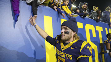 Nov 23, 2024; Morgantown, West Virginia, USA; West Virginia Mountaineers quarterback Garrett Greene (6) celebrates with fans after defeating the UCF Knights at Mountaineer Field at Milan Puskar Stadium. Mandatory Credit: Ben Queen-Imagn Images