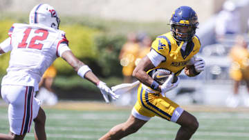 Aug 30, 2025; Morgantown, West Virginia, USA; West Virginia Mountaineers wide receiver Cam Vaughn (4) catches a ball and runs for extra yards during the first quarter against the Robert Morris Colonials at Milan Puskar Stadium. Mandatory Credit: Ben Queen-Imagn Images
