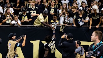 Sep 8, 2024; New Orleans, Louisiana, USA;  New Orleans Saints running back Jamaal Williams (21) hands his towel to a fan before heading to the locker room after the game against the Carolina Panthers at Caesars Superdome. Mandatory Credit: Stephen Lew-Imagn Images