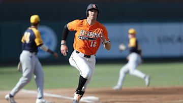 May 28, 2021; Oklahoma City, Oklahoma, USA; Oklahoma State outfielder Carson McCusker (12) advances home after hitting a home run against West Virginia during the Big 12 Conference Baseball Tournament at Chickasaw Bricktown Ballpark. Mandatory Credit: Alonzo Adams-Imagn Images