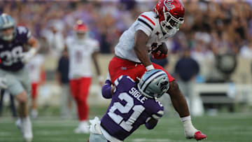 Arizona Wildcats running back Quali Conley (7) looks to avoid a tackle from Kansas State Wildcats safety Marques Sigle (21) during the first quarter of the game against Kansas State at Bill Snyder Family Stadium Friday, September 13, 2024.