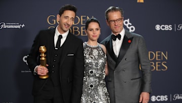 Jan 5, 2025; Beverly Hills, CA, USA; Adrien Brody, winner of best performance by a male actor in a motion picture drama for The Brutalist, with Felicity Jones and Guy Pearce at the 82nd Annual Golden Globe Awards at the Beverly Hilton Hotel in Beverly Hills, California on Sunday, Jan. 5, 2025. Mandatory Credit: Dan MacMedan-USA TODAY