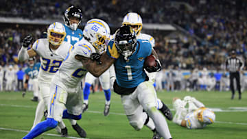 Jacksonville Jaguars running back Travis Etienne Jr. (1) rushes for yards against Los Angeles Chargers cornerback Asante Samuel Jr. (26) during the third quarter of an NFL first round playoff football matchup Saturday, Jan. 14, 2023 at TIAA Bank Field in Jacksonville, Fla. Jacksonville Jaguars edged the Los Angeles Chargers on a field goal 31-30. [Corey Perrine/Florida Times-Union]

Jki 011423 Chargers Jags C 54
