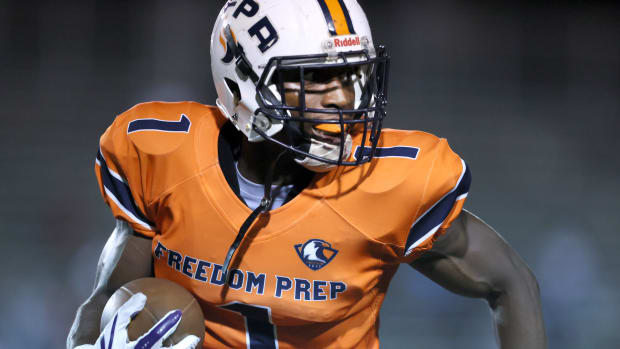 Freedom Preparatory Academy's Tyler Woodard races in for a touchdown reception in a high school game.