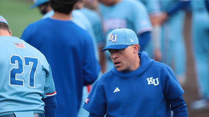 Kansas head baseball coach Dan Fitzgerald walks past players before the start of the game against Wichita State at Hoglund Ballpark on April 14, 2026.