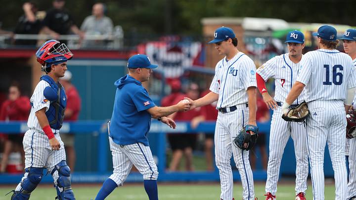 Kansas Jayhawks coach Dan Fitzgerald grabs the ball from Dominic Voegele (12) during the NCAA Lawrence Super Regional game at Hoglund Ballpark on June 6, 2026.