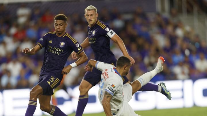 Aug 9, 2024; Orlando, Florida, USA; Cruz Azul forward Giorgos Giakoumakis (11) is tackled by Orlando City defender Robin Jansson (6) and defender Rafael Santos (3) during the first half at INTER&CO Stadium. Mandatory Credit: Morgan Tencza-USA TODAY Sports