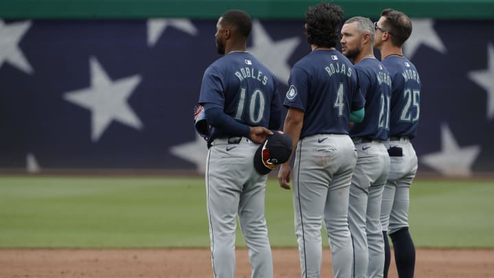 Seattle Mariners center fielder Victor Robles (10) and third baseman Josh Rojas (4) and first base coach Kristopher Negrón (21) and second baseman Dylan Moore (25) stand for the playing of God Bless America during the seventh inning stretch against the Pittsburgh Pirates at PNC Park on Aug 18.