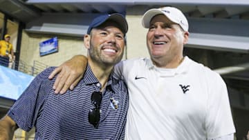Sep 13, 2025; Morgantown, West Virginia, USA; West Virginia Mountaineers head coach Rich Rodriguez celebrates with West Virginia University athletic director Wren Baker after defeating the Pittsburgh Panthers at Milan Puskar Stadium. Mandatory Credit: Ben Queen-Imagn Images