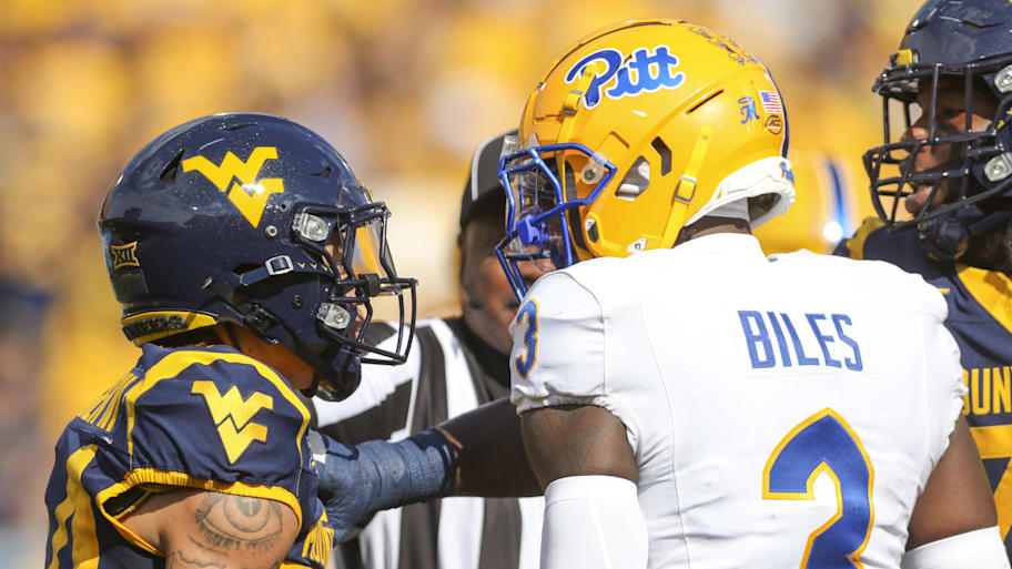 West Virginia wide receiver Rodney Gallagher III, left, and Pittsburgh linebacker Rasheem Biles exchange words on Sept. 13.