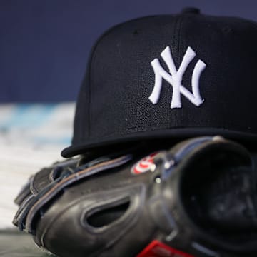 Aug 14, 2023; Atlanta, Georgia, USA; A detailed view of a New York Yankees hat and glove on the bench against the Atlanta Braves in the third inning at Truist Park. Mandatory Credit: Brett Davis-Imagn Images