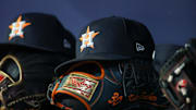 Apr 21, 2023; Atlanta, Georgia, USA; A detailed view of a Houston Astros hat and glove in the dugout against the Atlanta Braves in the fifth inning at Truist Park. 