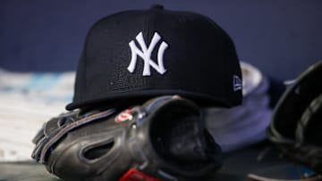 Aug 14, 2023; Atlanta, Georgia, USA; A detailed view of a New York Yankees hat and glove on the bench against the Atlanta Braves in the third inning at Truist Park. 