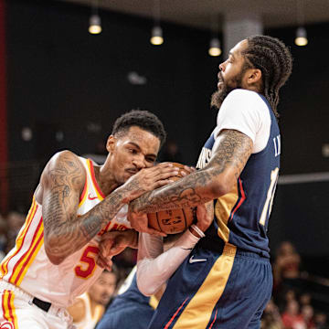 Oct 14, 2023; College Park, Georgia, USA; Atlanta Hawks guard Dejounte Murray (5) and New Orleans Pelicans forward Brandon Ingram (14) fight for the ball during the first quarter at Gateway Center Arena at College Park. 