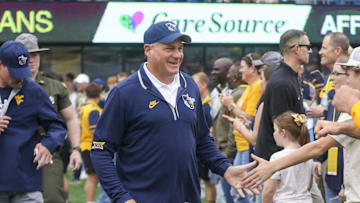 Sep 27, 2025; Morgantown, West Virginia, USA; West Virginia Mountaineers head coach Rich Rodriguez walks on the field and greets fans before their game against the Utah Utes at Milan Puskar Stadium. Mandatory Credit: Ben Queen-Imagn Images